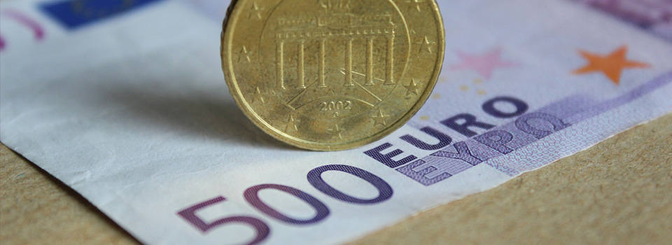 Palkanlaskenta sivun headerkuva 20 euron seteli ja kolikko pöydällä