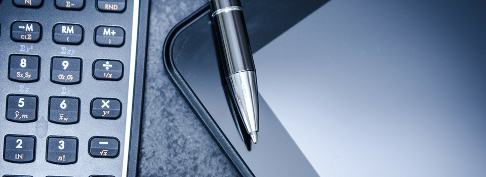 Tilitoimistopalvelut sivun headerkuva laskin, kynä ja tabletti pöydällä